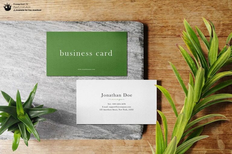 موکاپ کارت ویزیت روی میز چوبی در کنار گلدان